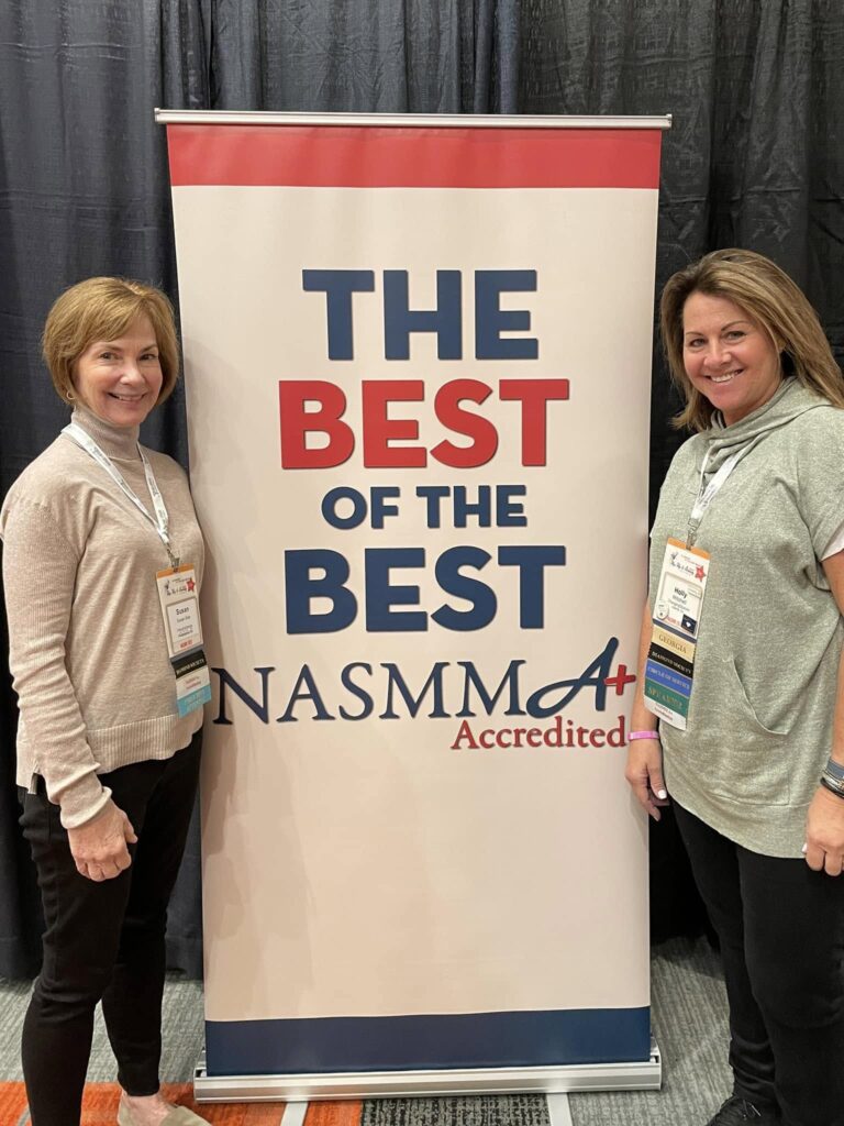 ChangingSpaces founders Holly Mitchell and Linda Kaplan beside the NASMM Best of the Best A+ Accredited banner