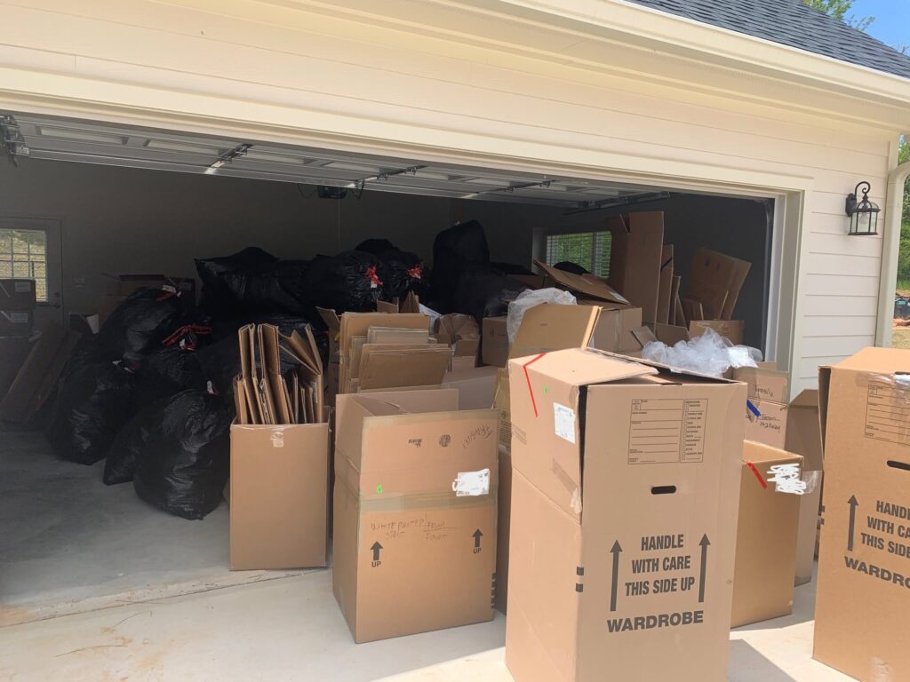 Garage of an Atlanta home filled with packed moving boxes and wardrobe boxes ready for moving day